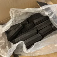Open doos met House of Charcoal hexagon briketten – zwart geperst houtskool verpakt in plastic